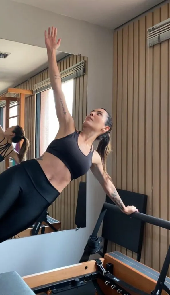 Paula Valério executando exercício de pilates em equipamento de estúdio na clínica